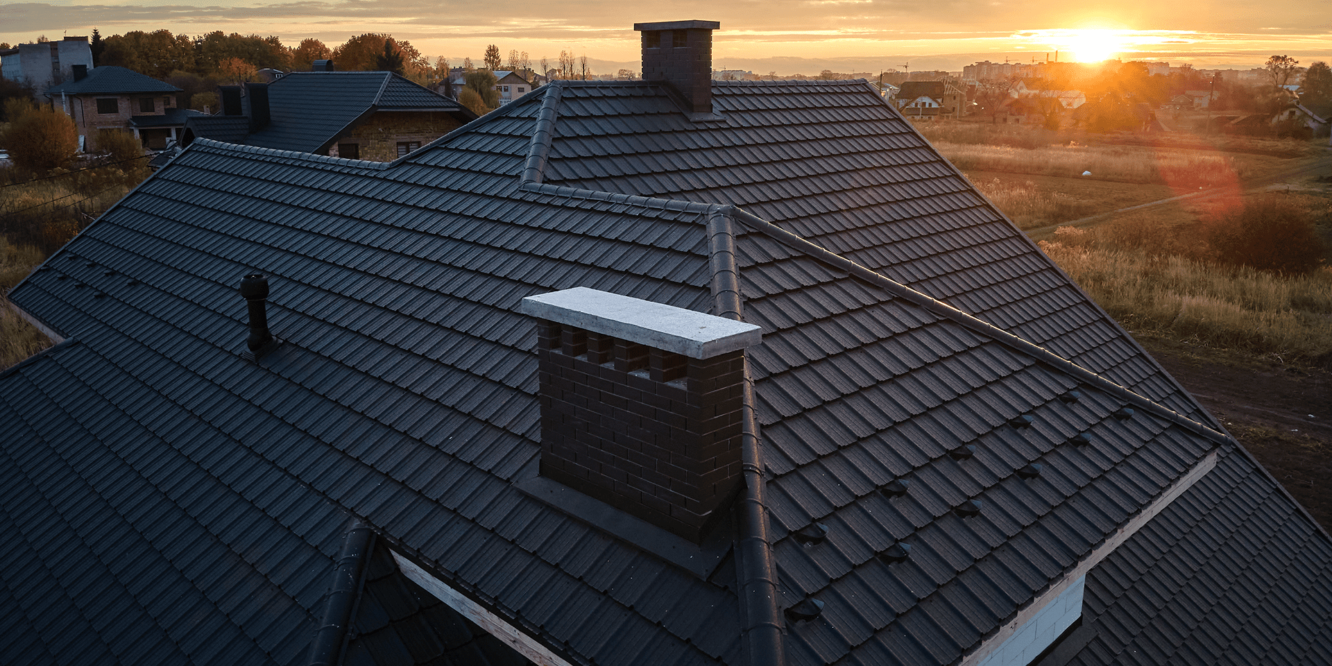 House roof with chimney at sunset
