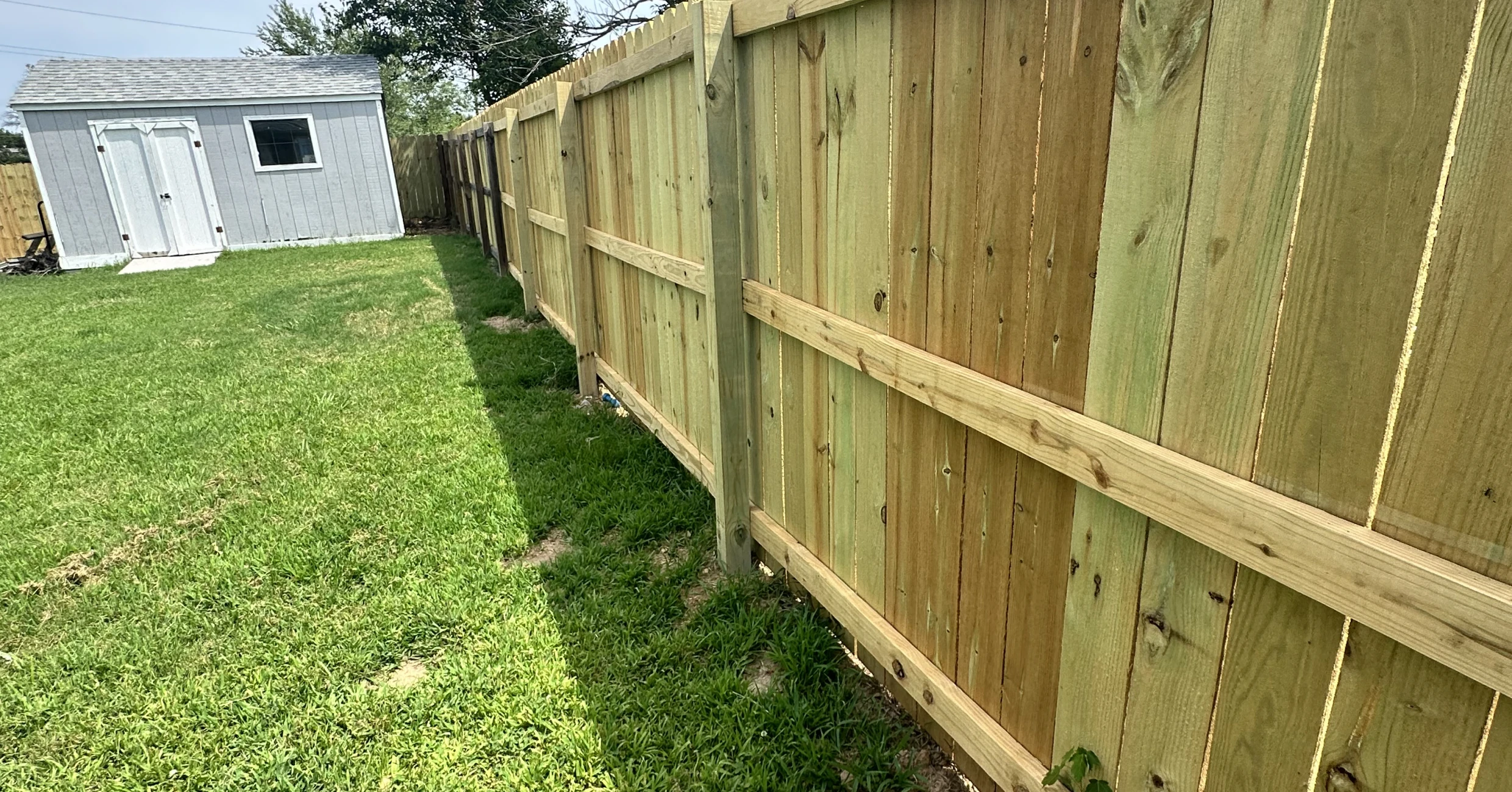 Wooden fence beside a green lawn